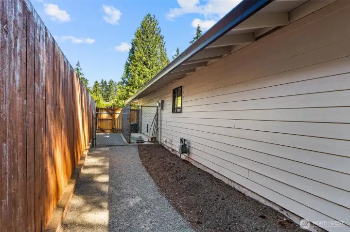 Side yard with dog yard with pet door into garage. Side yard with dog yard with pet door into garage.