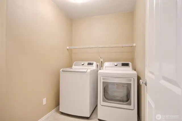 Big laundry room with shelving, sandwiched between the bedrooms where you need it.