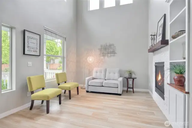 Formal living room with gas fireplace & tall ceilings with added natural light