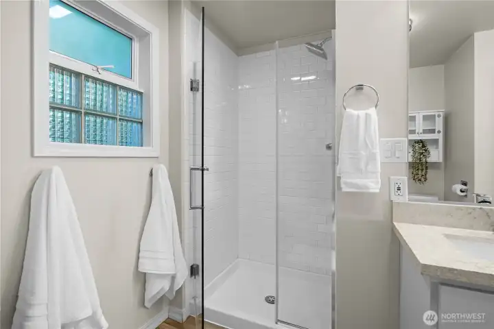 Modern, updated main floor bathroom with a spacious layout featuring a separate soaking tub and walk-in shower for added luxury and convenience.