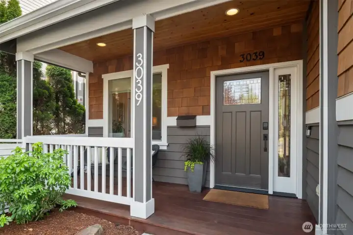 A cozy covered front porch perfect for morning coffee awaits!