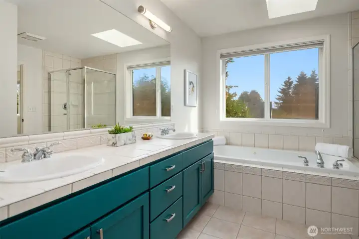 Large en-suite bath with double sink vanity, jetted tub, and additional shower.