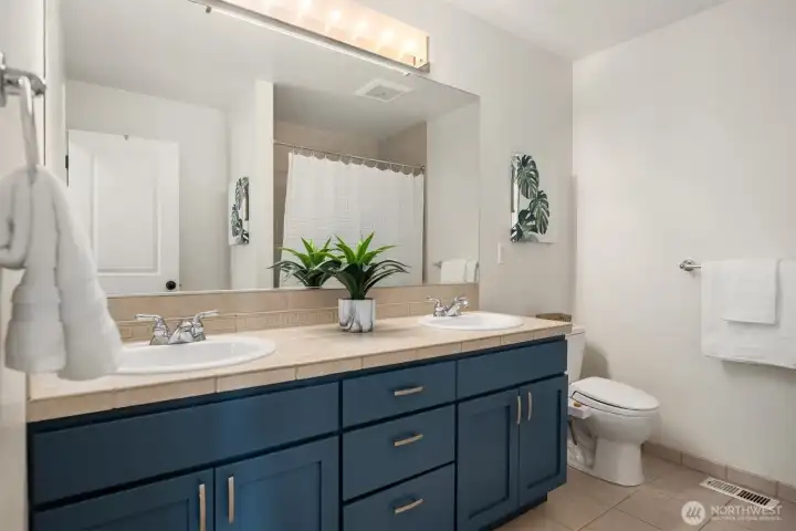 An additional bath with double sinks off the hallway.
