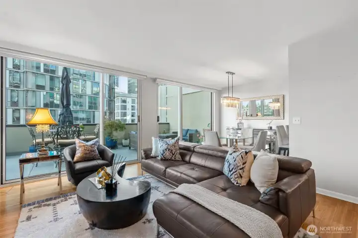 Bright open-concept living and dining space with floor-to-ceiling windows.