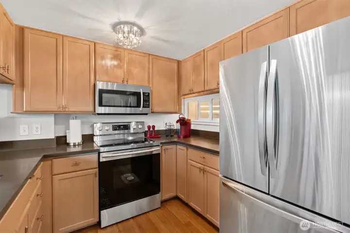 Modern kitchen with sleek cabinetry, stone countertops, and stainless-steel appliances.
