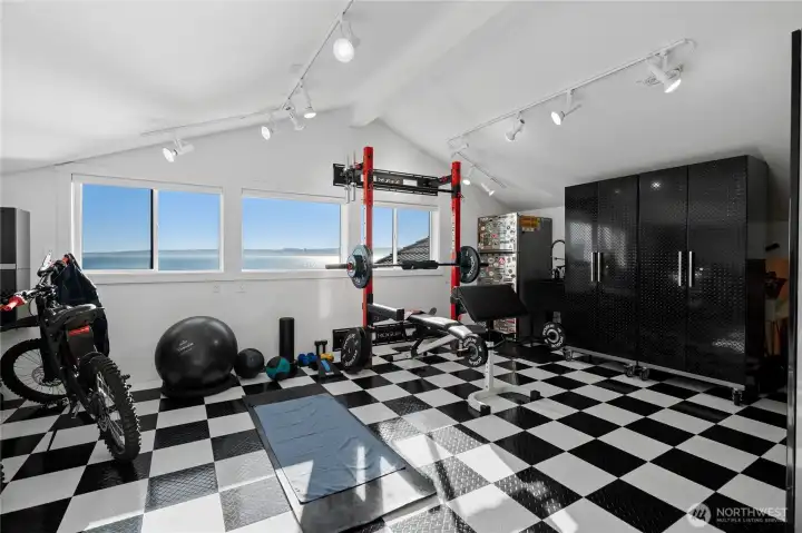 Bonus space off of the garage makes for a great workout room with a high-end Rogue fold-back wall mount gym rack system already installed
