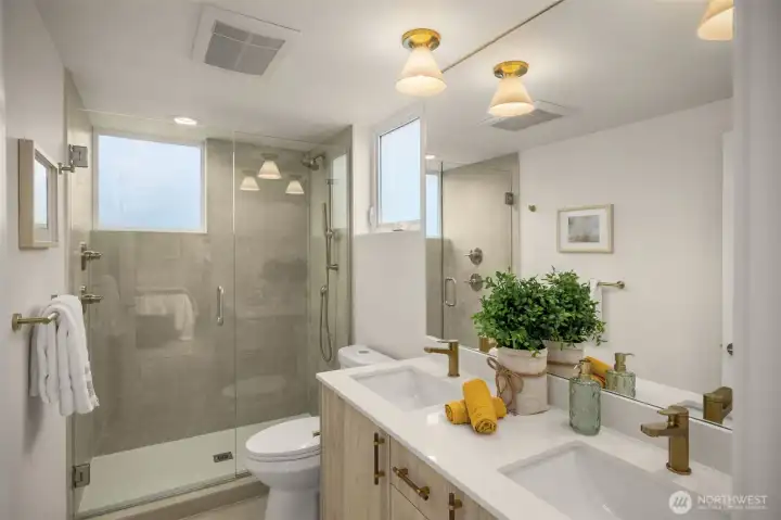 Primary bath with dual vanities and walk-in shower.