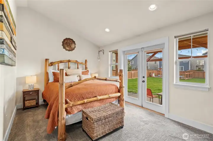 Enjoy a primary bedroom on the main level with French doors leading to the backyard patio and charming pergola.