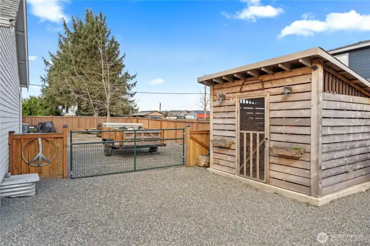 Side gate entrance and cute shed for storage.