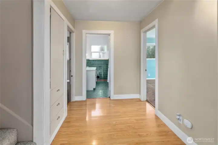 Right off the living room and kitchen is this massive hallway with custom original built ins looking into the main floor bathroom and two bedrooms.