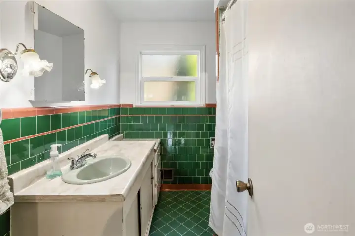 Main floor full bathroom with original tile work and lights, love the vintage vibe in here.