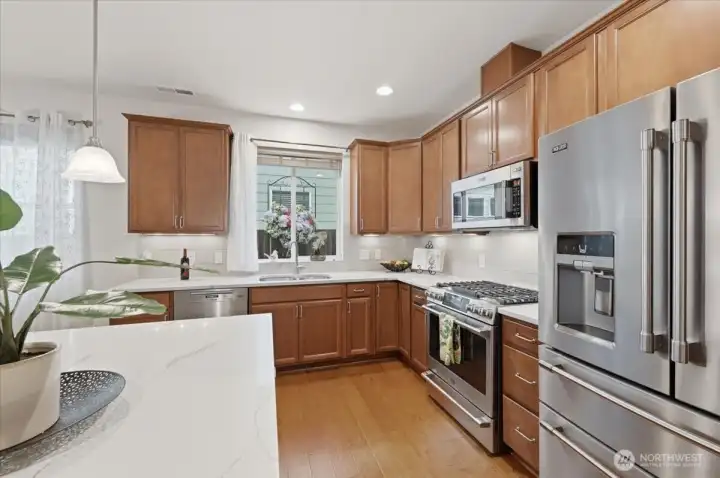 Window above the sink, quartz counter tops, gas range - all enhance the kitchen space.