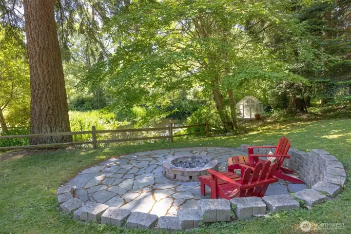 Gather around the flagstone firepit as the sun sets over the pond, surrounded by beautiful towering trees. Gather around the flagstone firepit as the sun sets over the pond, surrounded by beautiful towering trees.