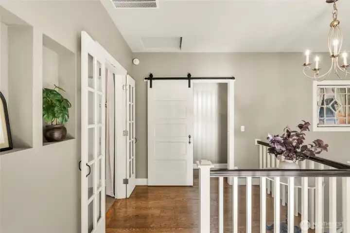 Glass french doors on the Den, Primary Suite thru the Barn Door.
