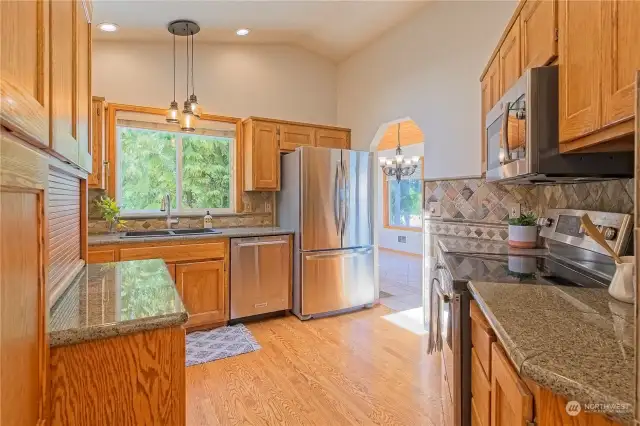 A warm and welcoming kitchen featuring granite counters, stainless appliances and endless storage.