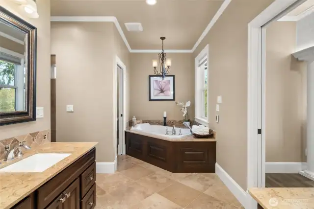 Step into the exquisite primary bathroom, where every detail has been designed with both luxury and comfort in mind. The large window next to the Jacuzzi tub frames a breathtaking view of the mountains, allowing you to soak in nature’s beauty while relaxing in your personal spa. Crown molding adds an elegant touch, while the gorgeous walk-in tile shower and radian heated floors bring modern sophistication to this space. Dual vanities provide ample storage, making mornings a breeze.