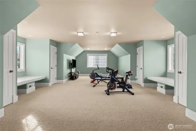 An extraordinarily extra-large bonus room offers endless possibilities! Bathed in natural light, this expansive space features two charming window sitting areas—perfect for curling up with a book and enjoying a peaceful retreat. Thoughtfully designed with four generous closets, this versatile room can effortlessly transform into a private suite. With the addition of a bathroom and a kitchen, it becomes a fully functional living space—ideal for multi-generational living, a luxurious guest retreat, or even an income-generating rental. Whether used as a media room, game room, or converted into a grand primary suite, this space adapts to your lifestyle with elegance and ease.