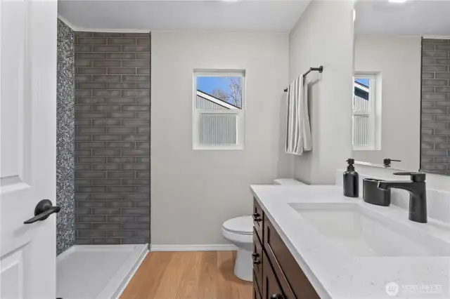 A/Main Floor: Primary En Suite Bath w/New Vanity w/Quartz Counter, Laminate Floors and Custom Tiled Shower. (Bath 1)