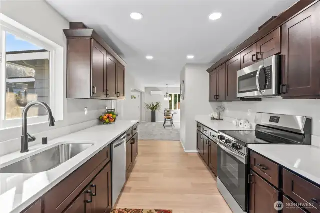 A/Main Floor: Kitchen w/New Cabinets w/Crown Molding, Quartz Counters & Backsplash. Double Stainless Steel Sink w/New Faucet.
