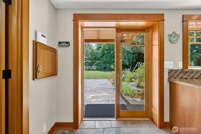 French doors lead to the spacious backyard with patio space, vegetable and flower garden, shaded dog run and large lawn.