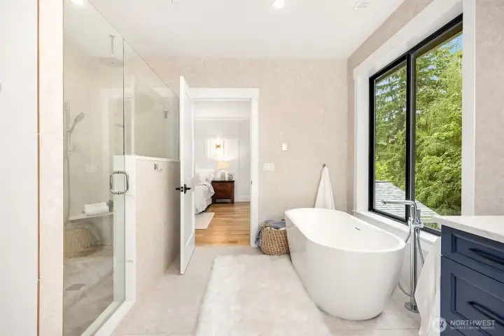 Primary bathroom: Luxurious Spa-like bathroom with freestanding slipper tub, Twin vanities set in a quartz countertop with ample navy blue cabinetry, Tile walk-in shower for two with four shower heads, Floor-to-ceiling ceramic tiled walls add to the high-end feel of this peaceful bathroom retreat, Heated tile floors...