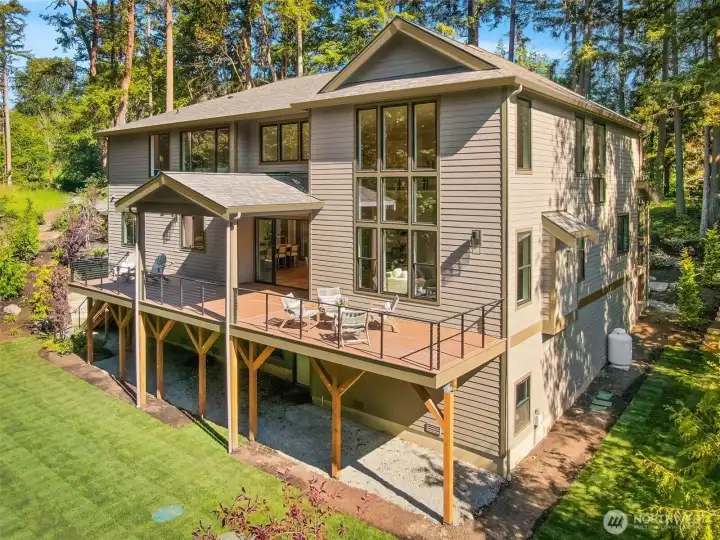 The back of the house boasts a partially covered massive deck and plenty of room to run around on the grassy lawn.