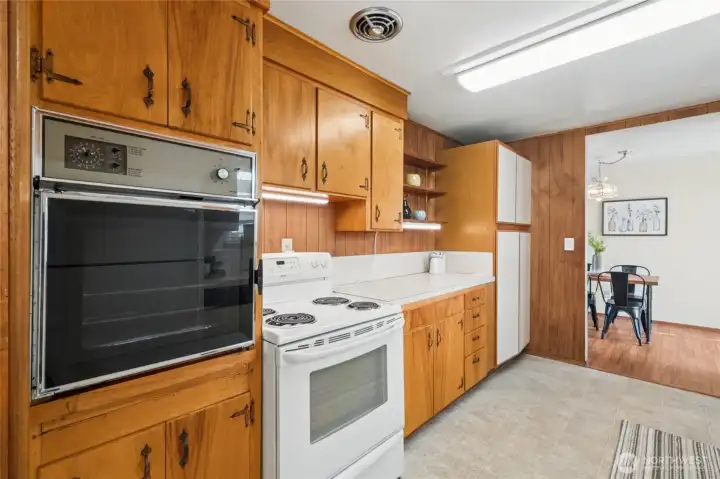 Looking from the other end you can see the really "vintage" oven, which does work, but you have the range/cooktop combo to utilize. Large pantry on the left with slide out drawers on the bottom.