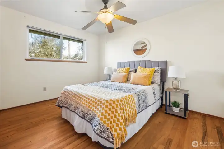 Good sized primary bedroom with a wall of closets. Original hardwood floors here and ceiling fan.