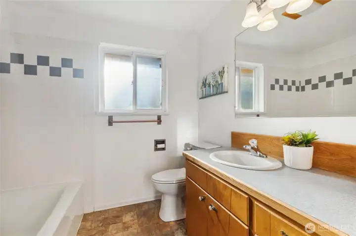 Spacious bathroom with tub/shower combination on the left, plus to the right out of the photo is floor to ceiling storage with so much ROOM!