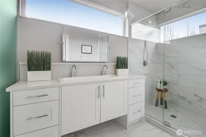Elegant primary bath with glass-enclosed shower.