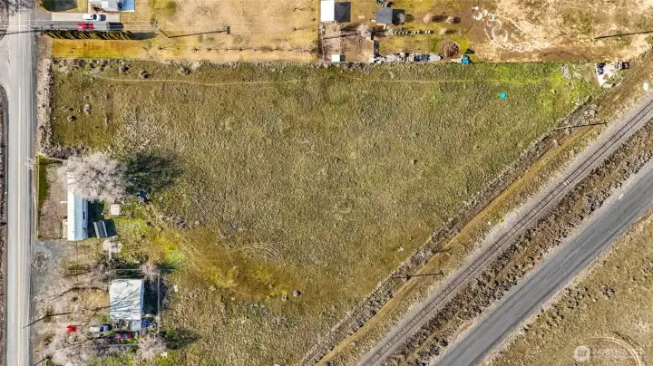 Maple frontage on the left, RR tracks on the right side of this photo. The house right next door is occupied and not part of the vacant land listing.