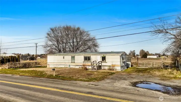 This singlewide is a fixer upper on the property. Value is in the land. A fence surrounds the property. The house right next door is occupied and not part of the vacant land listing.