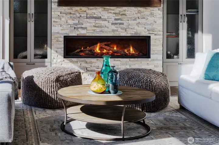 Gather by the fire, with custom built-in cabinets nearby