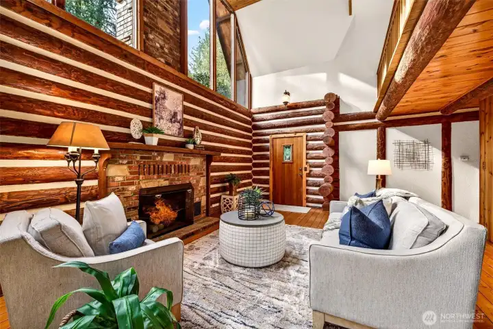 Soaring gable windows flood the great room with natural light, while the brick fireplace and hand-scribed log walls deliver authentic cabin character — a living space that is as stunning architecturally as it is comfortable to live in.