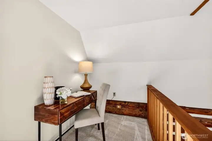 Tucked beneath the roofline at the top of the stairs, this quiet upper-level nook provides a natural spot for a home office, reading retreat, or creative workspace — an unexpected bonus that adds real everyday flexibility to the floorplan.