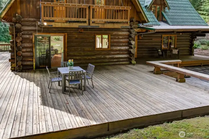 The expansive rear deck wraps the back of the home and offers exceptional scale for outdoor living — whether hosting a summer gathering or simply unwinding in the shade of old-growth trees, this outdoor space delivers on every level.