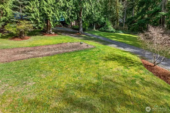 Expansive open lawn areas bordered by established evergreen plantings offer outstanding usable outdoor space — whether for gardening, recreation, or simply enjoying the quiet of a private 3.71-acre setting with no HOA restrictions.
