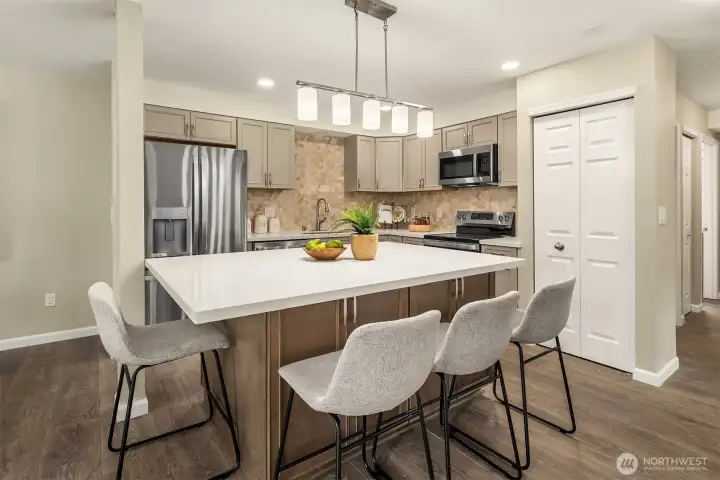 Brand New Kitchen offers a center island w/ storage & Quartz Counter Tops,  Tiled Backsplash, New Lighting Fixtures, All new SS Appliances, and Pantry Closet