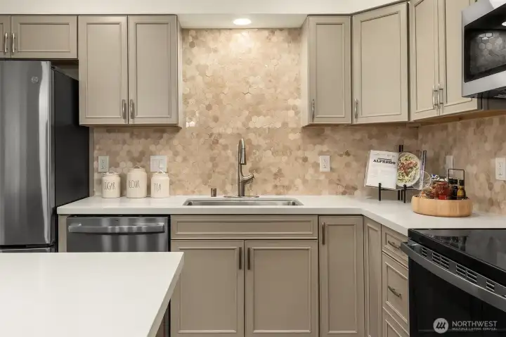 Totally Renovated Kitchen w/ nice cabinetry offering soft close hinges, pull out drawers, Lazy Susan, Quartz Counter Tops, Tiled Backsplash, New SS Appliances, and beautiful island w/ breakfast bar!