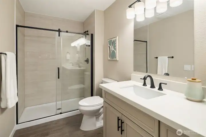 Enjoy this totally updated primary bathroom with big walk-in shower w/ glass enclosure, new toilet, lovely vanity with dual sinks & new lighting and outlets, flooring, and fixtures.