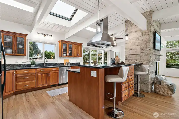 Updated chef’s kitchen featuring cherry cabinetry, granite countertops, and skylights.