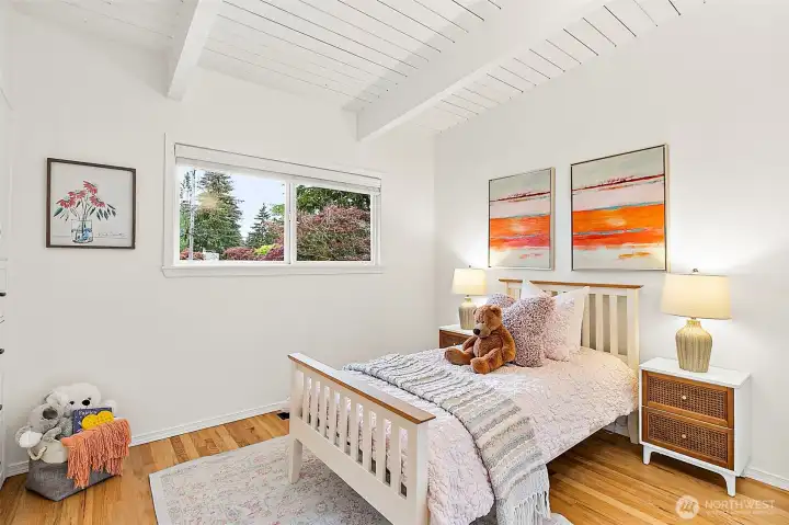 Secondary bedroom with hardwood floors and serene outlooks.