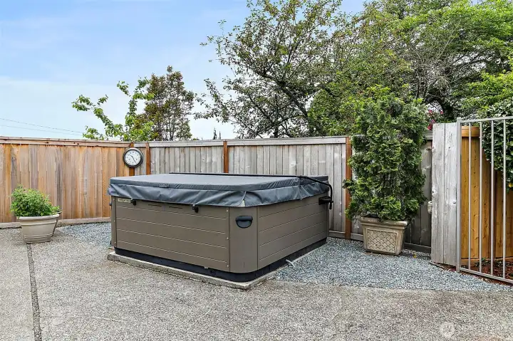 Resort-style hot tub retreat tucked within the fully fenced yard.