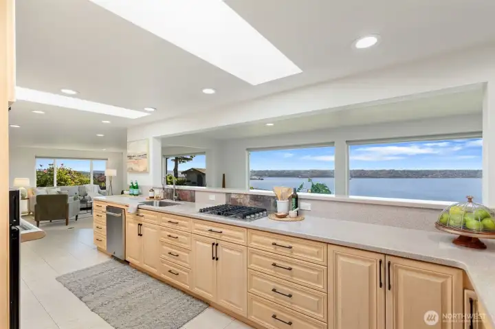 Bright kitchen with stunning views, tile floors, plenty of custom cabinets, and gas range.