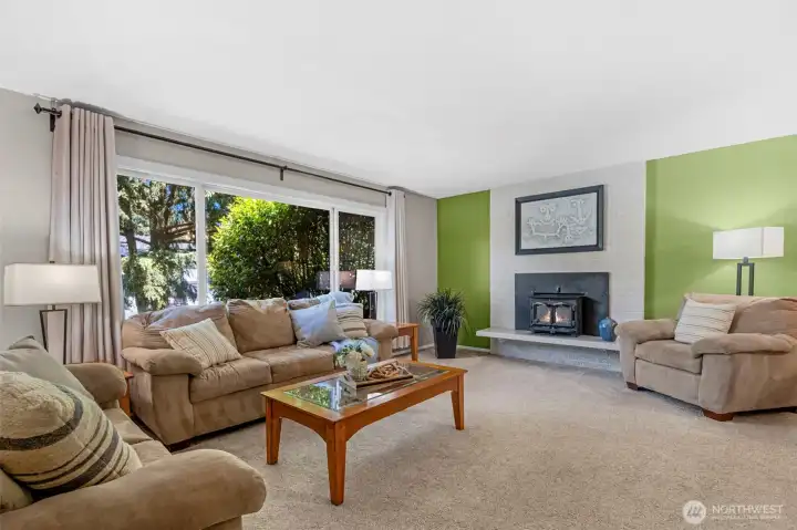 The living room with abundant natural light and a cozy gas fireplace