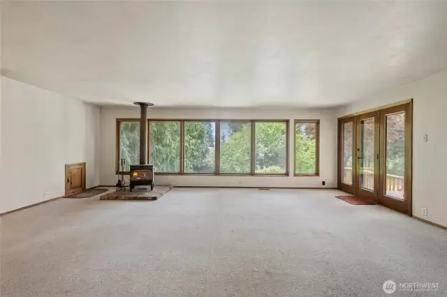 Large Living Room with wood burning stove and door leading out to the large back deck.