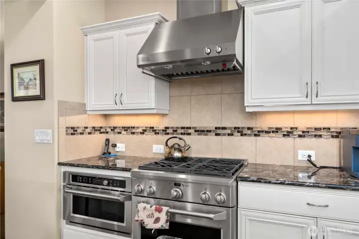 Top tier appliances and hood vent, integrated microwave, and full height backsplash.