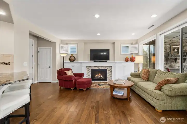 Gleaming Engineered hardwoods, a stunning fireplace with custom mantle and built-ins.
