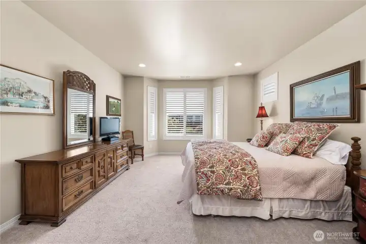 Primary bedroom with bay window and Plantation shutters.