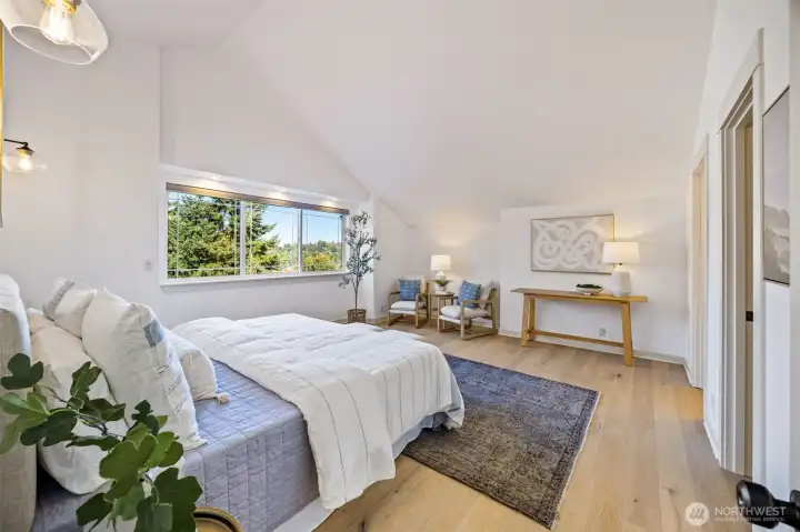 Generously sized primary bedroom with vailted ceilings, walk in closet, and en-suite bathroom